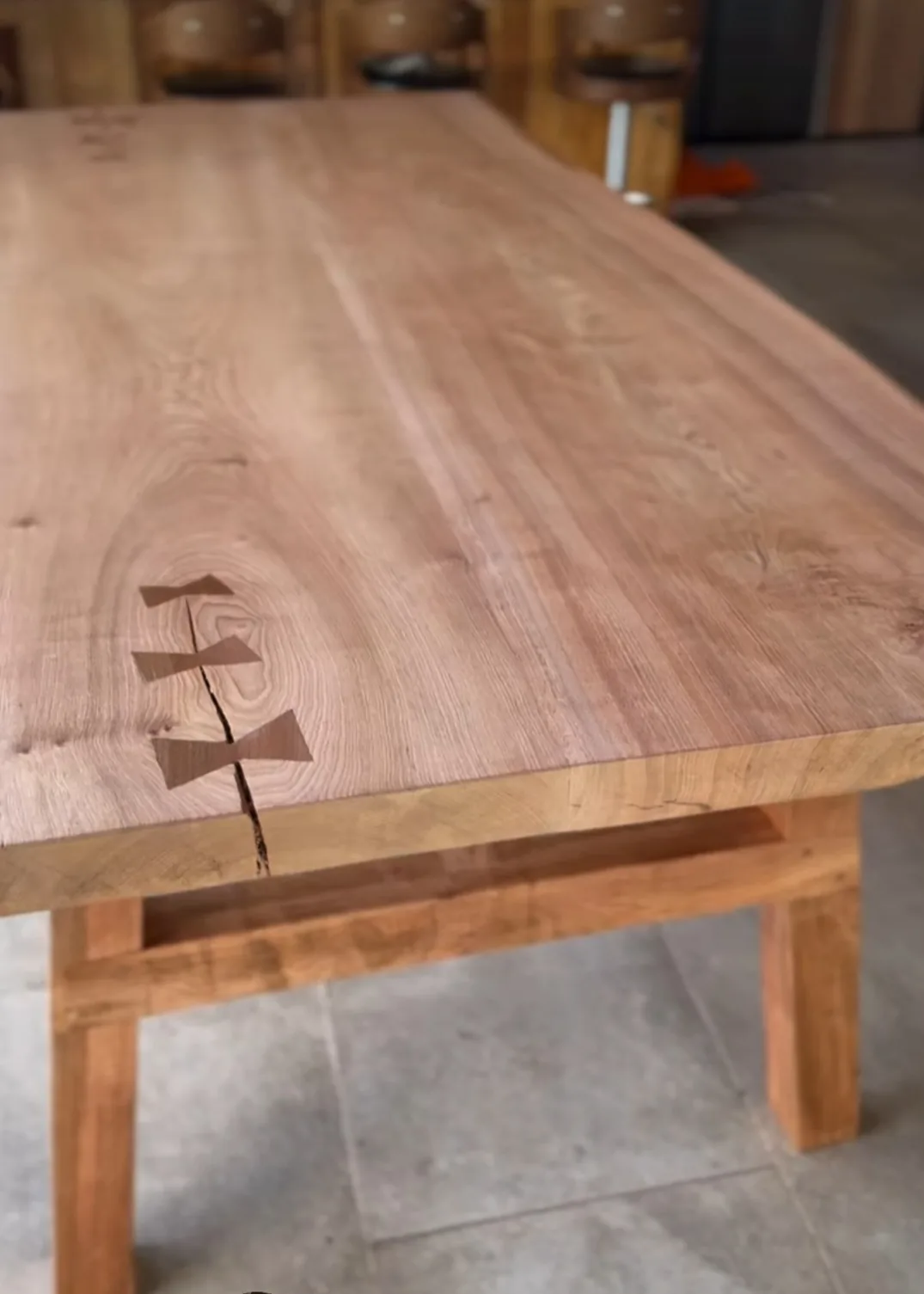 Cubierta de mesa con una grieta reforzada por uniones de madera oscura en forma de mariposa